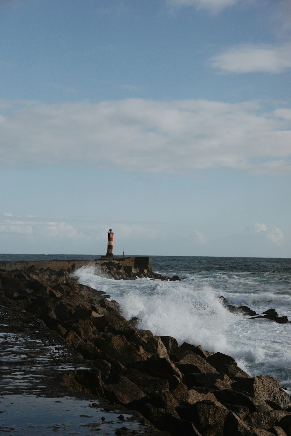 a lighthouse on a rocky shore near the ocean