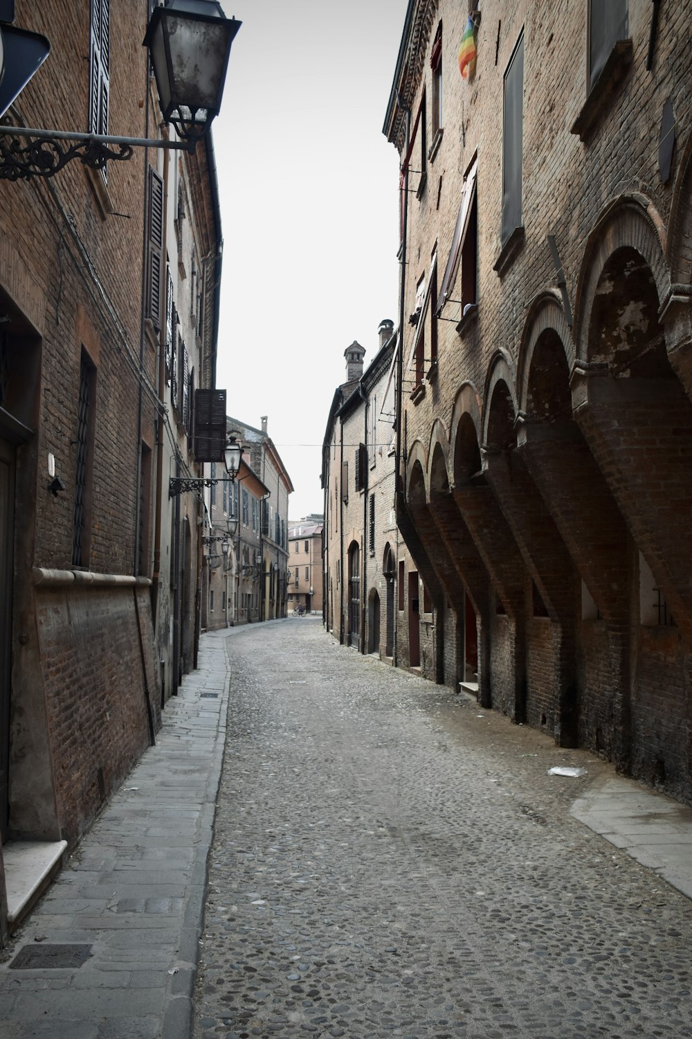 a cobblestone street lined with brick buildings