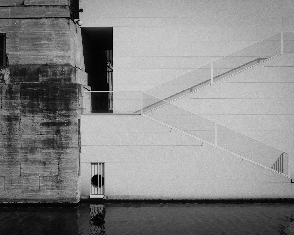 a black and white photo of a staircase next to a building