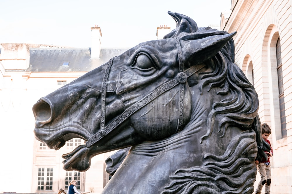 une statue d’un cheval devant un bâtiment