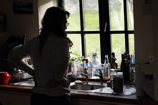 a woman standing in a kitchen next to a sink