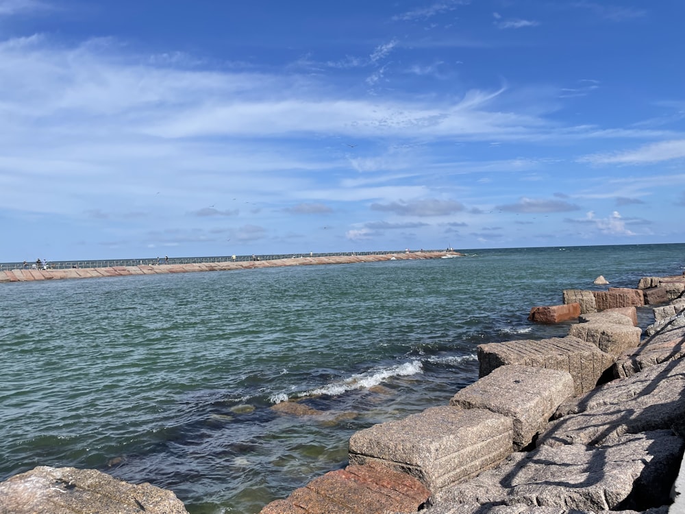 a person sitting on a bench next to the ocean