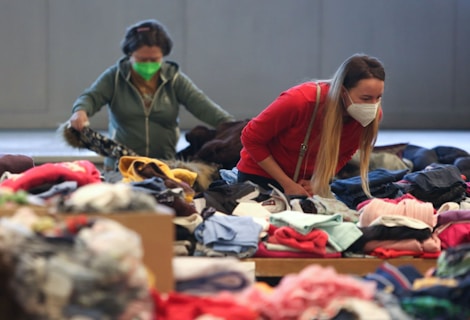 two women in a room filled with clothes and masks
