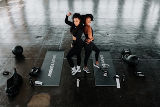 a couple of women standing on top of yoga mats