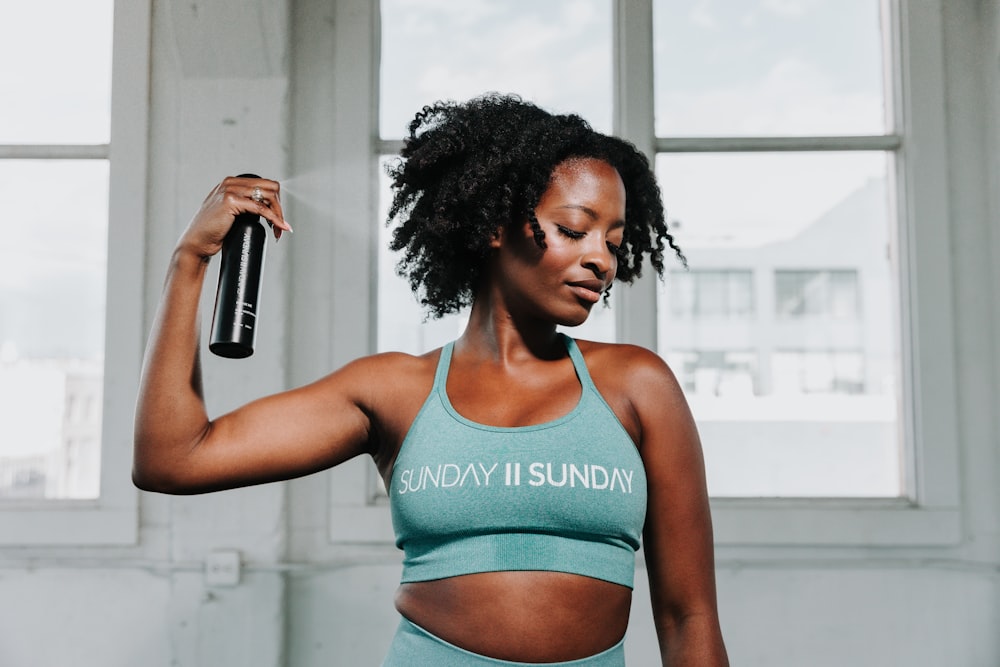 a woman holding a water bottle in her right hand