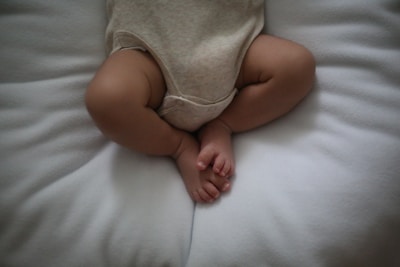 a baby laying on top of a white pillow