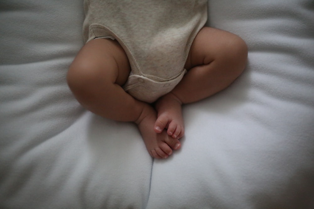 a baby laying on top of a white pillow