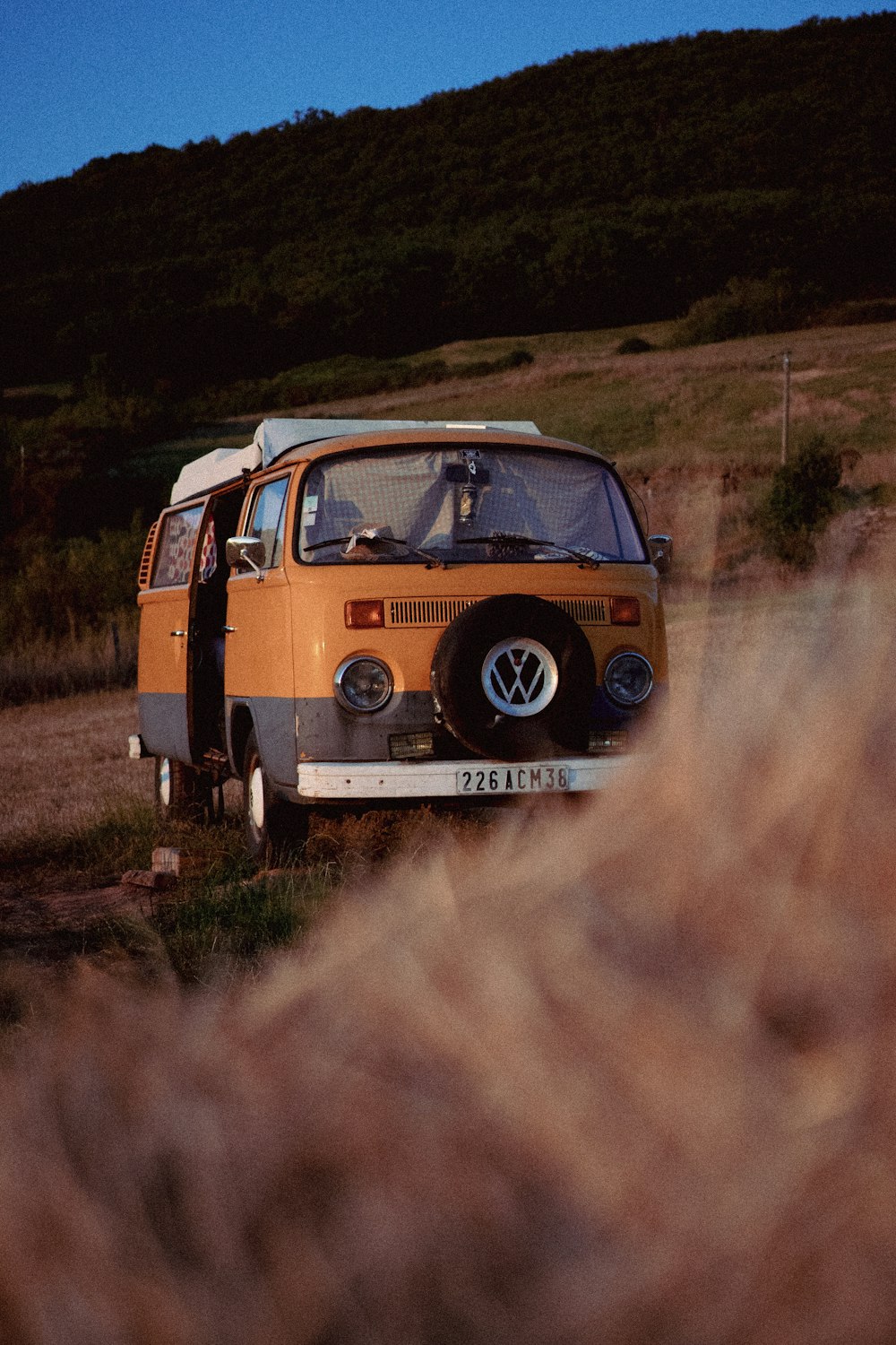 an old vw bus is parked on the side of the road