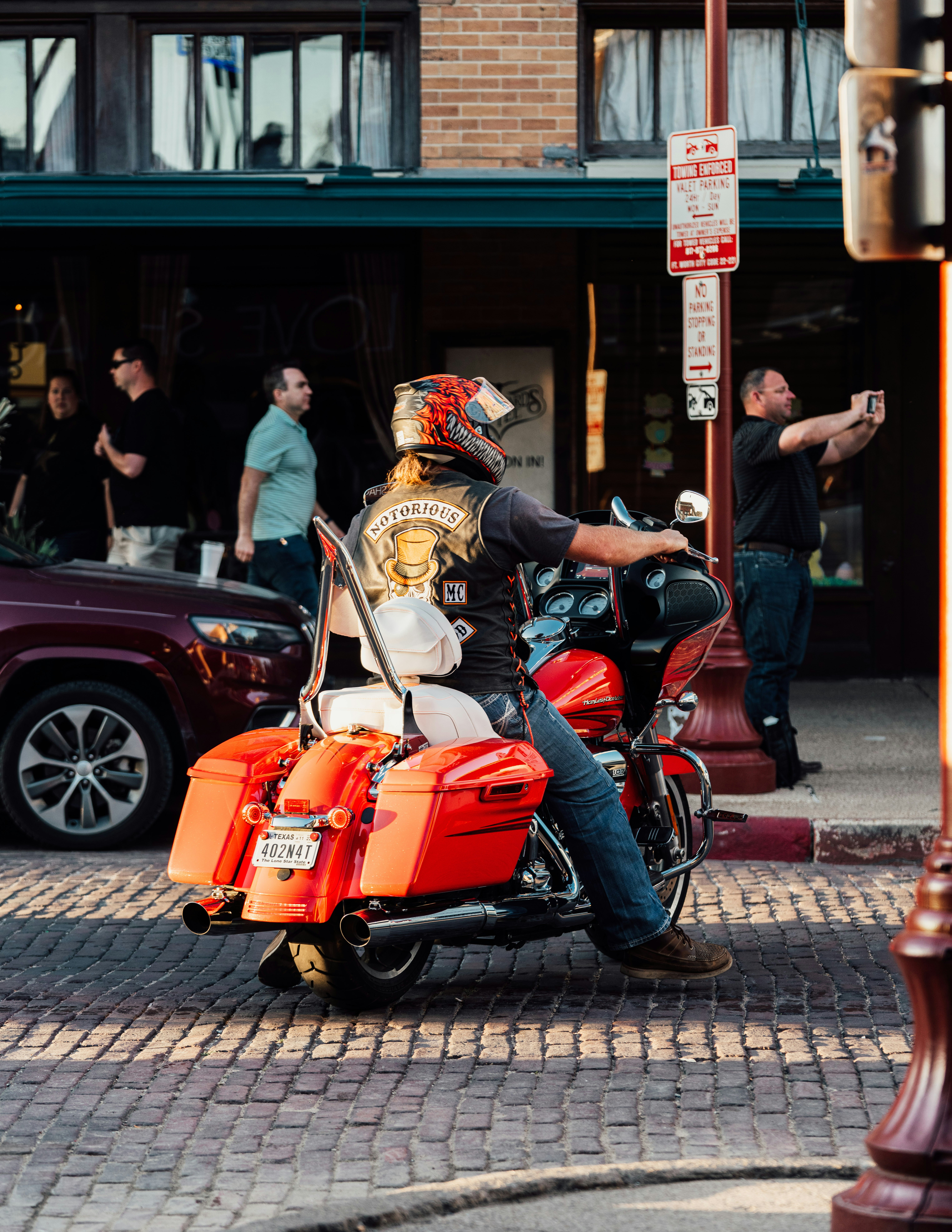 a man riding on the back of a motorcycle down a street