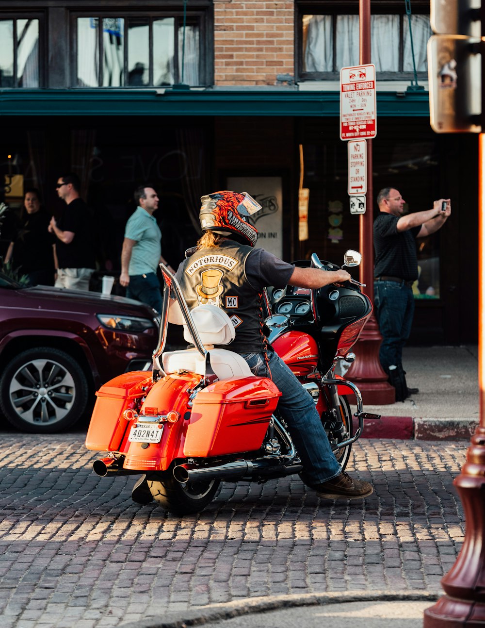 a man riding on the back of a motorcycle down a street