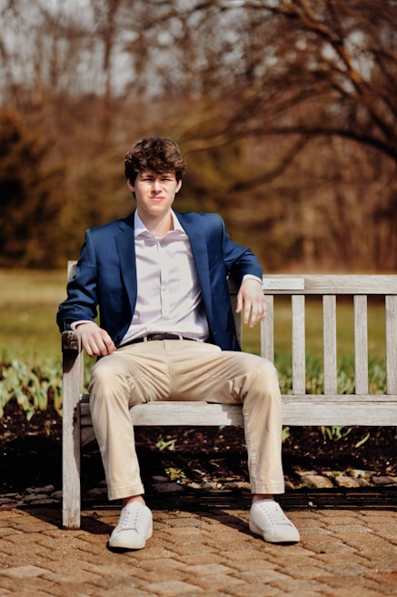 Casual campus look with a navy shirt and olive pants, styled effortlessly on a city bench.