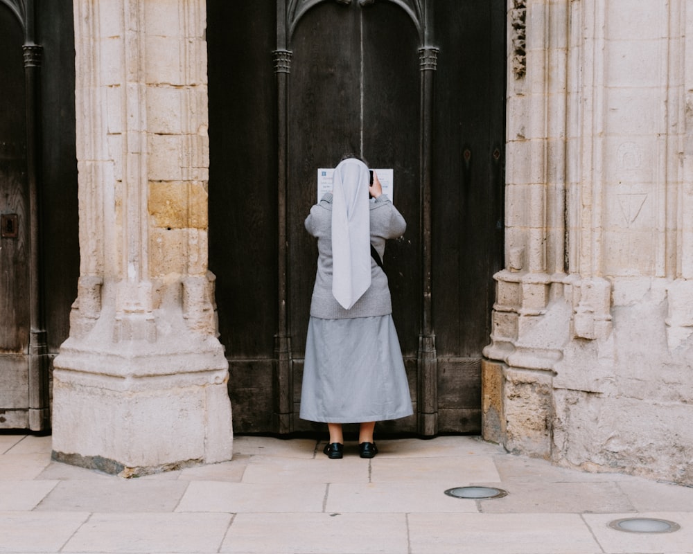 a woman standing in front of a black door