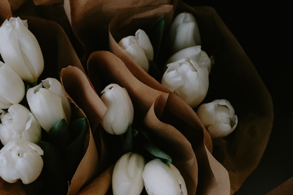 a bouquet of white tulips sitting on top of a table