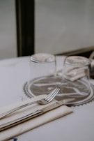 Modern stainless steel cutlery laid out beside a minimalist tableware set.