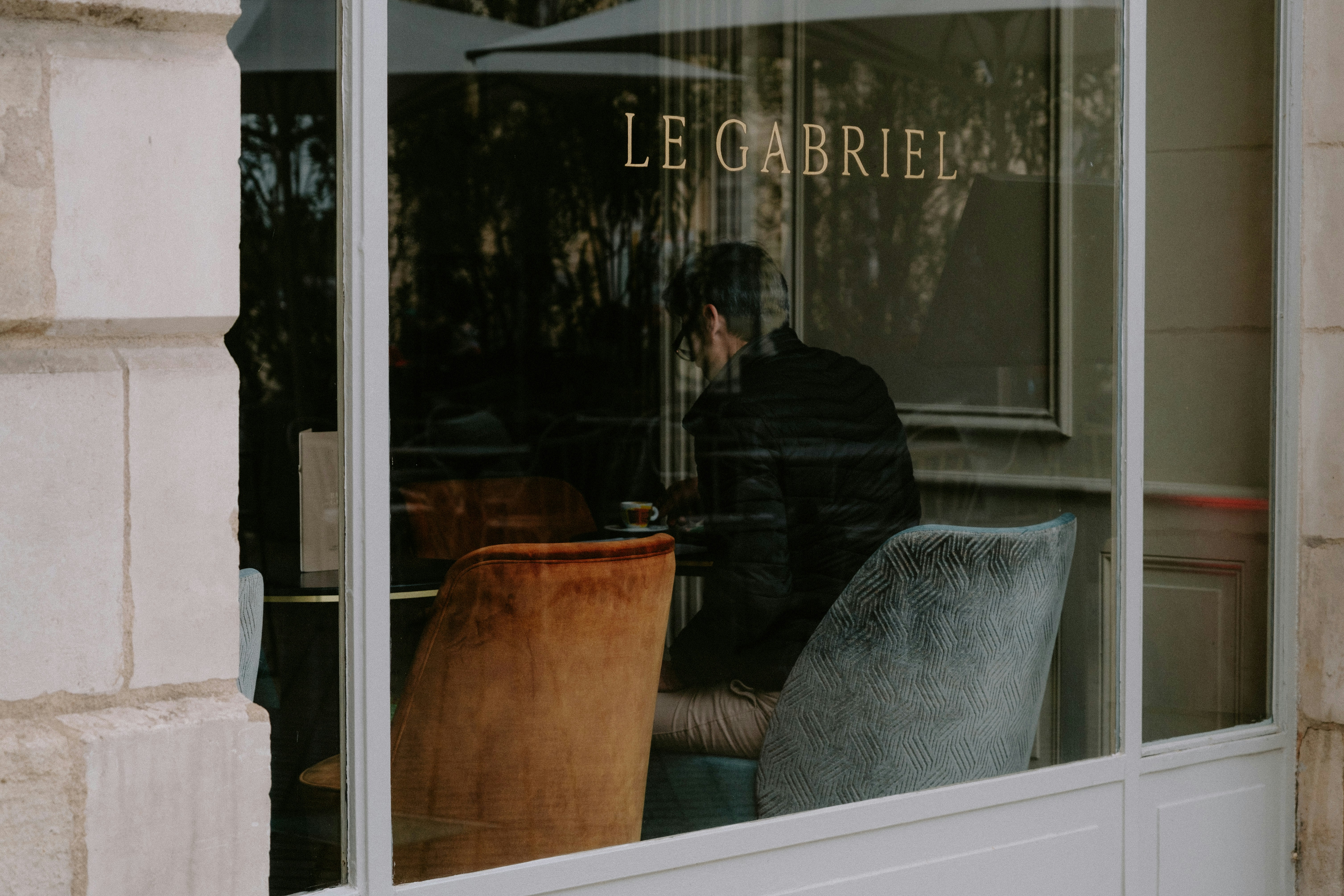 a man sitting at a table in front of a window