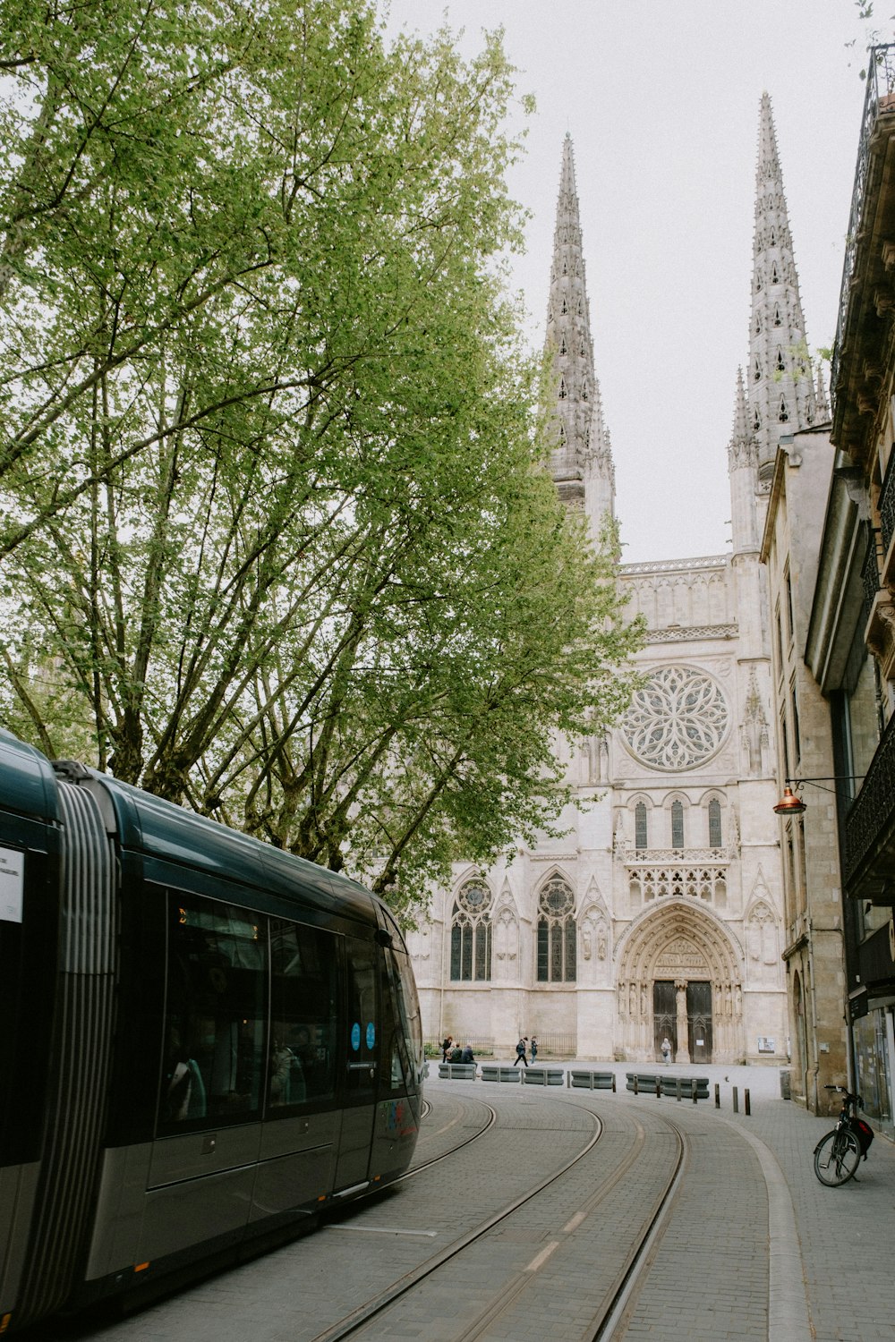 a train traveling down a street next to a tall building