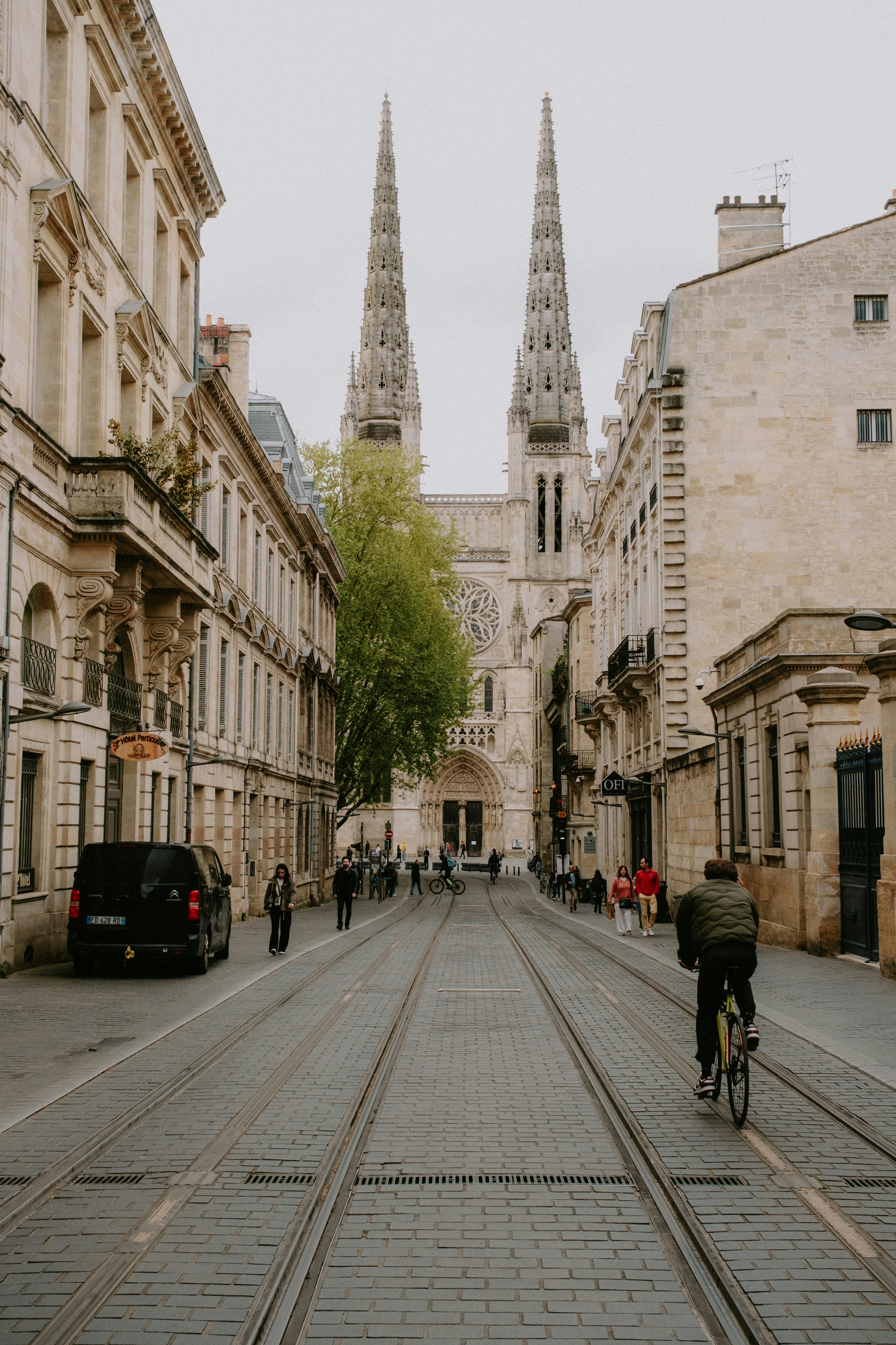 a man riding a bike down a street next to tall buildings