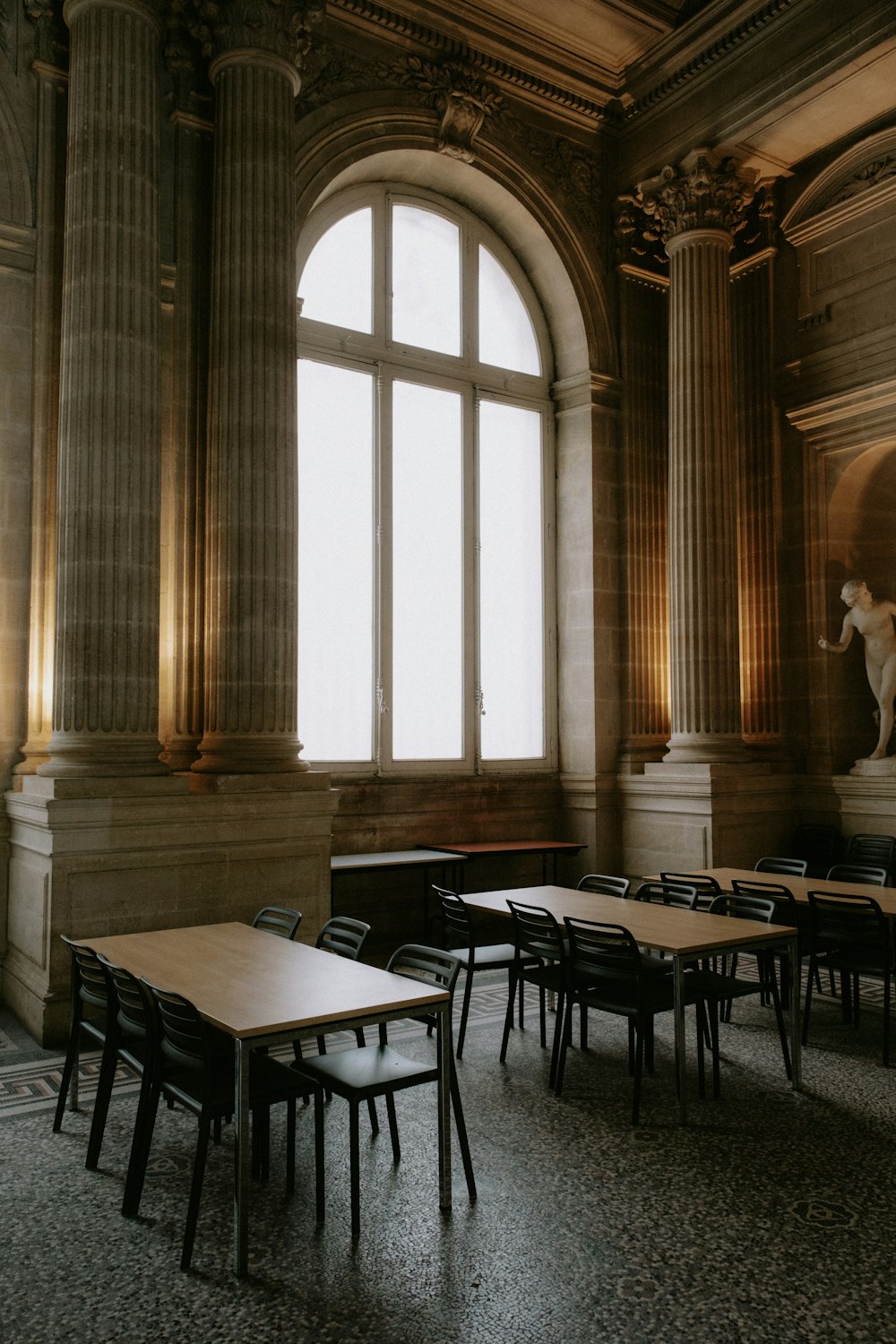 a room filled with lots of wooden tables and chairs