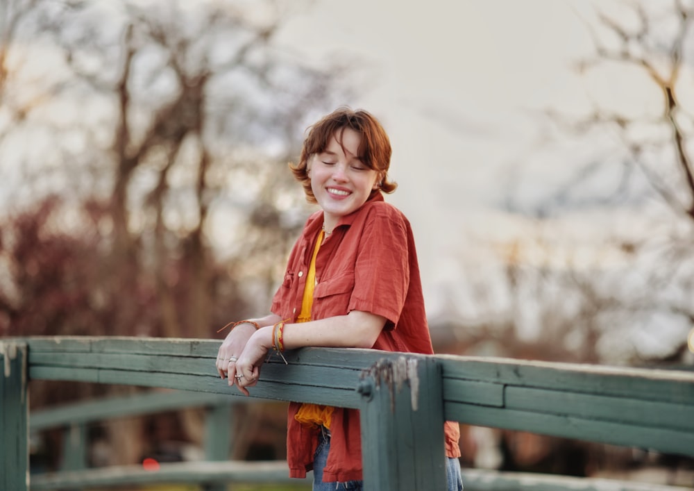 a woman standing on top of a wooden bridge