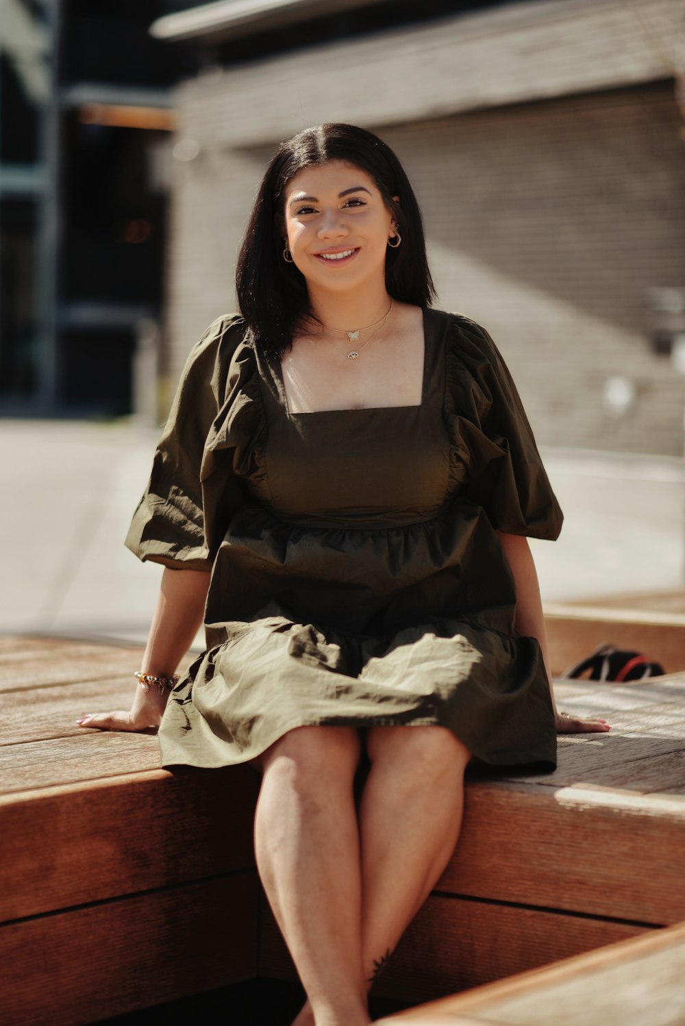 a woman sitting on a wooden bench smiling