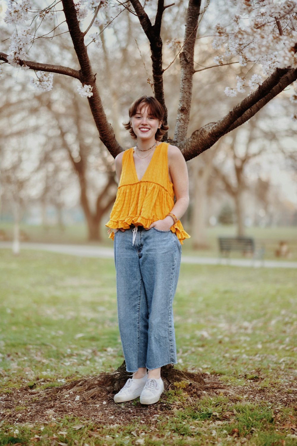 a woman standing in front of a tree