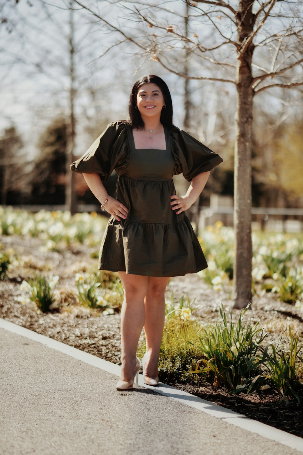 a woman standing on the side of a road