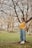a woman standing next to a tree in a park