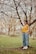 a woman standing next to a tree in a park