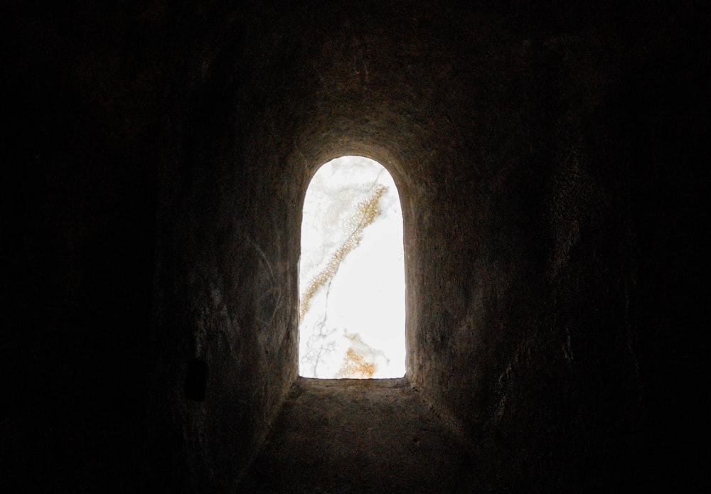 a dark tunnel with a small window in it