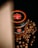 A jar of chocolate spread with an espresso flavor is placed on a black surface, surrounded by scattered coffee beans. The lid of the jar prominently displays a logo with the words 'Espoleto'. A soft light casts a shadow on the left side, creating a dramatic effect.