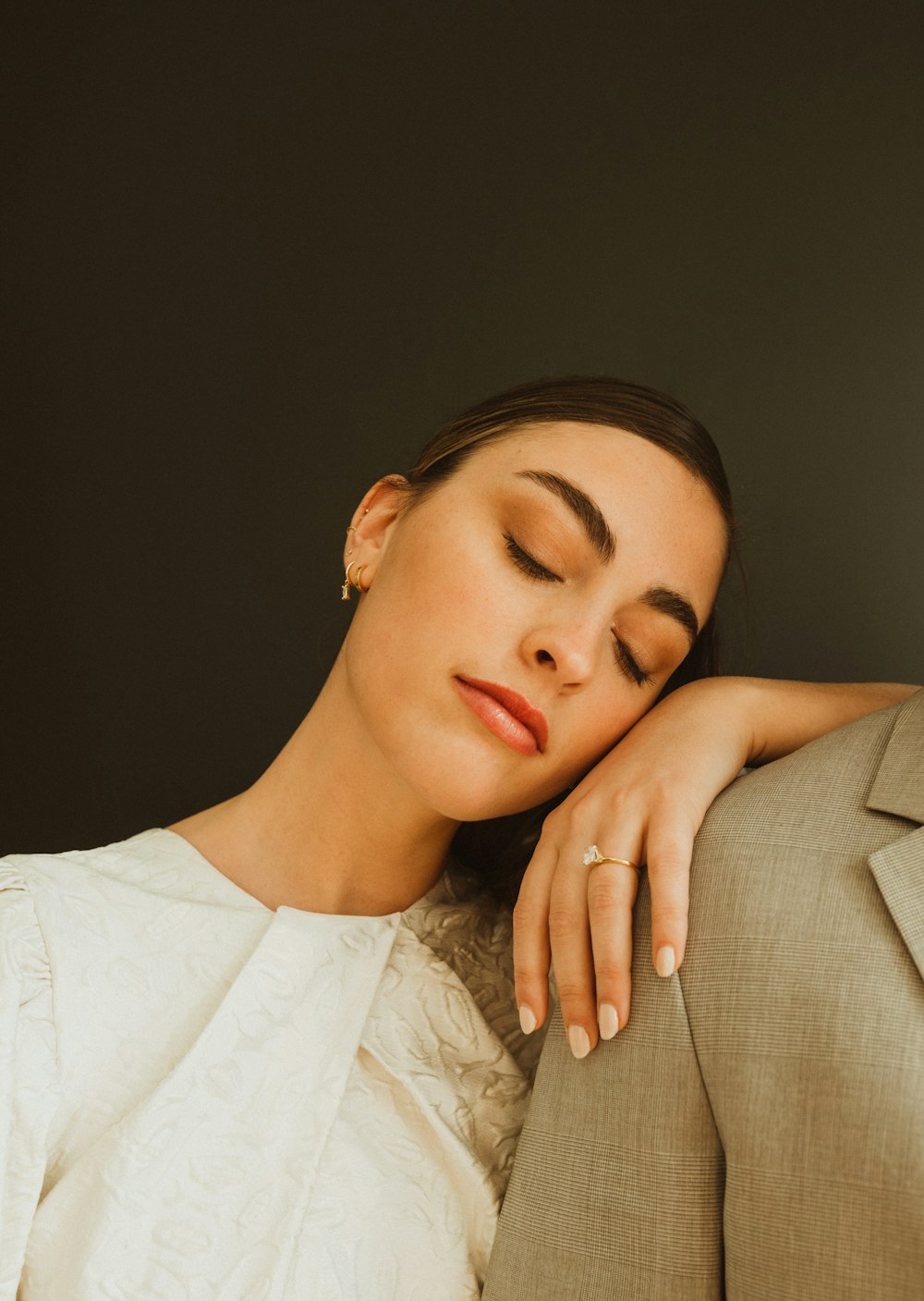 a woman with her eyes closed and her head resting on a man's shoulder