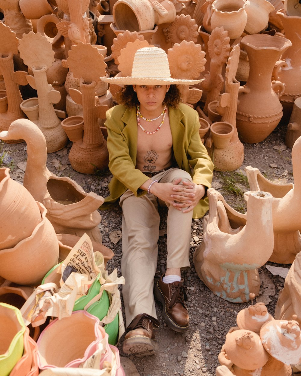 a woman sitting on a pile of clay pots
