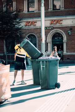 a person standing next to a trash can