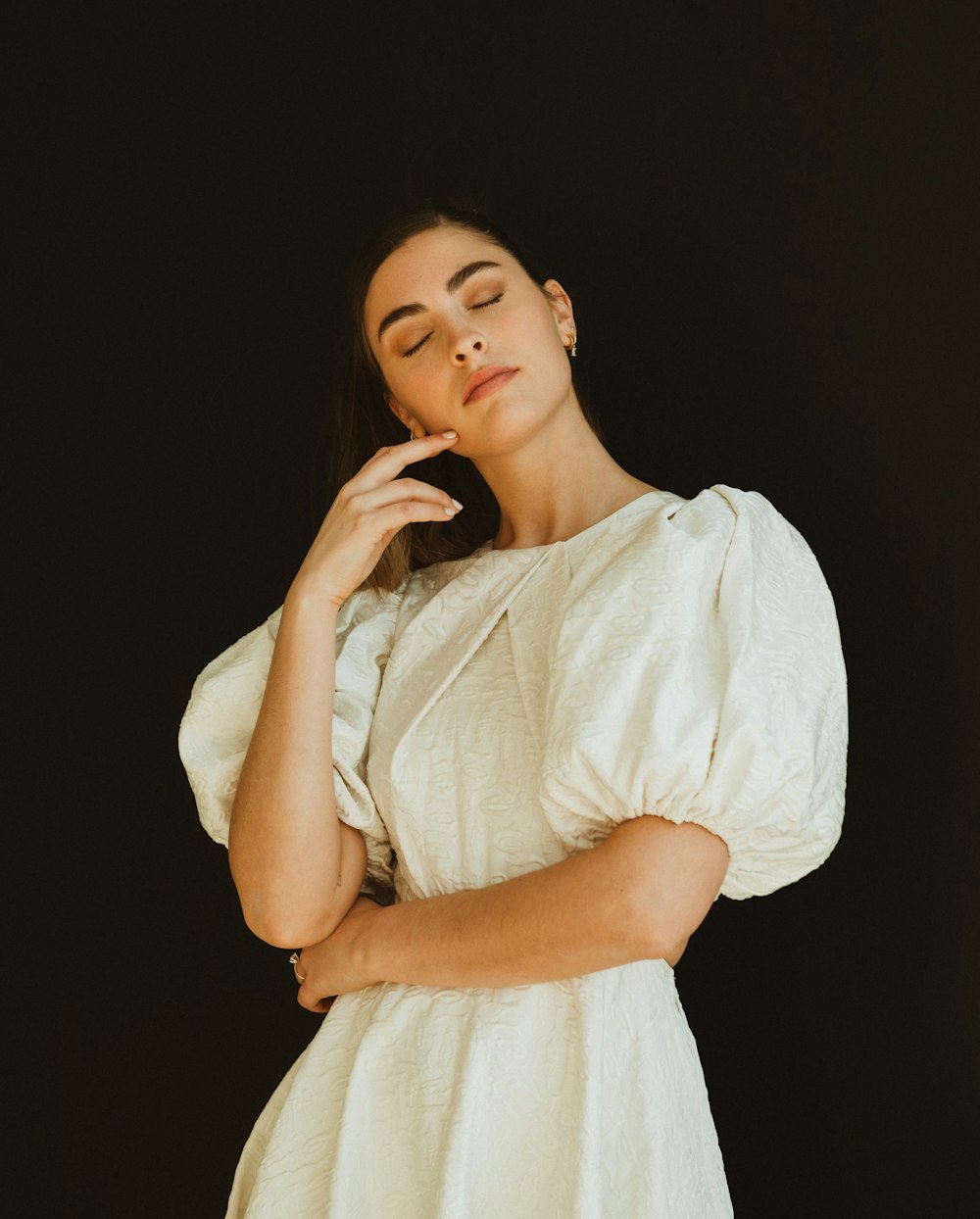 a woman in a white dress posing for a picture