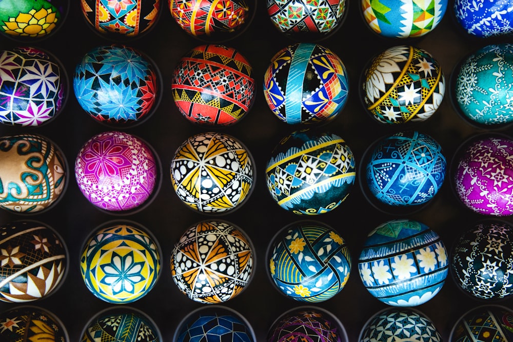 a bunch of colorful painted eggs in a box