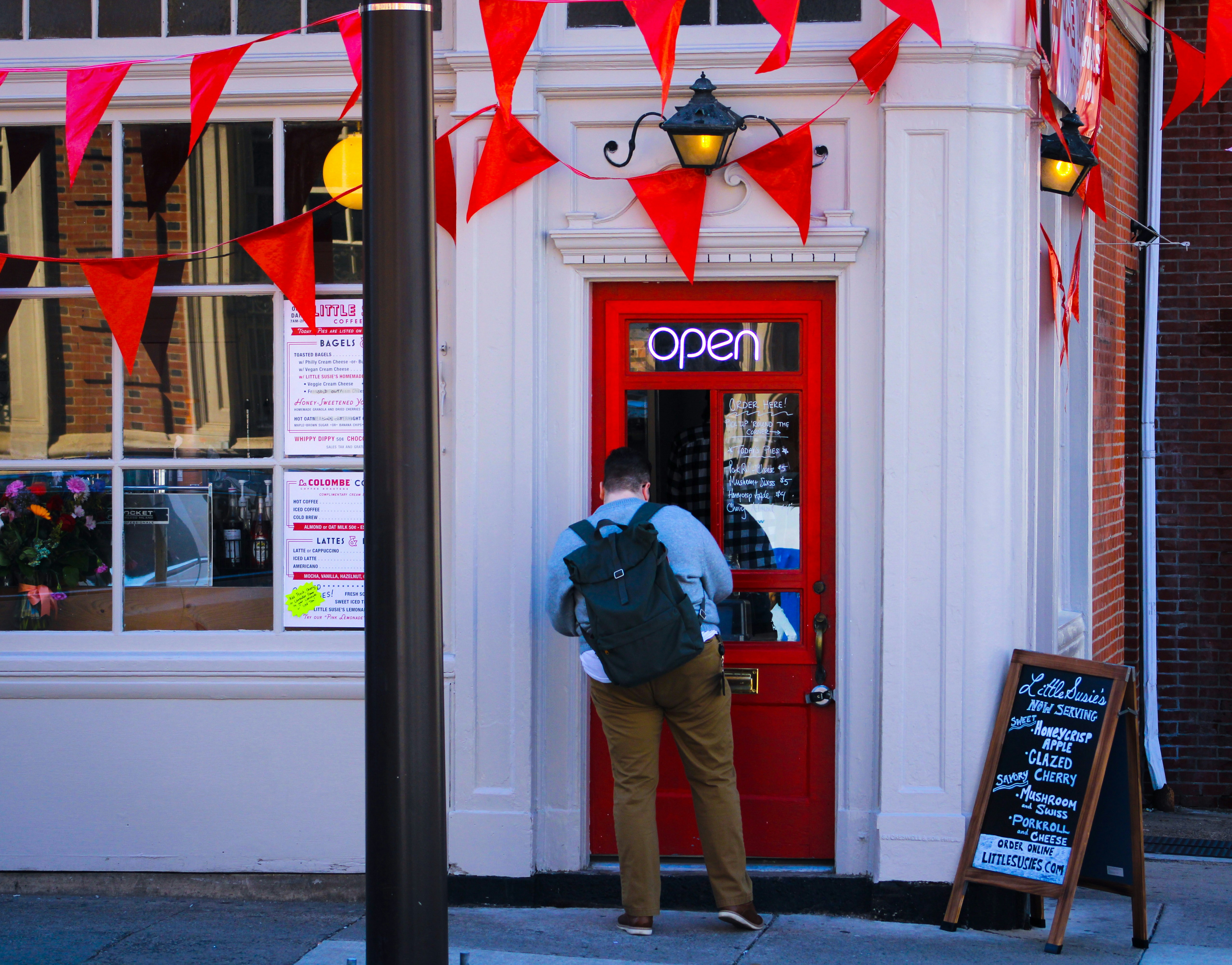 赤いドアの前に立つ男