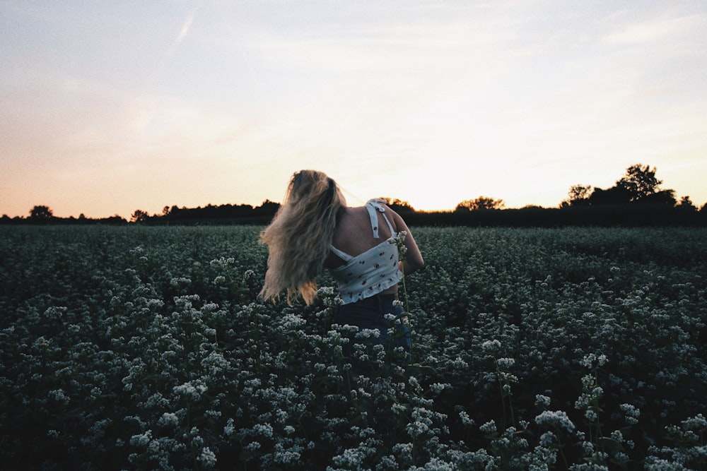 a woman standing in a field of flowers