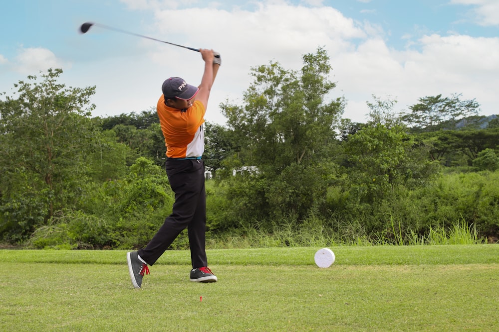 a man swinging a golf club at a ball