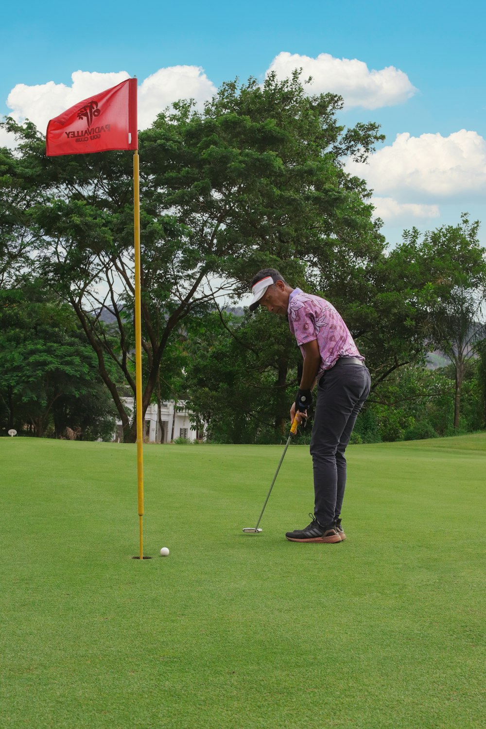 a man putting a putt on a golf course