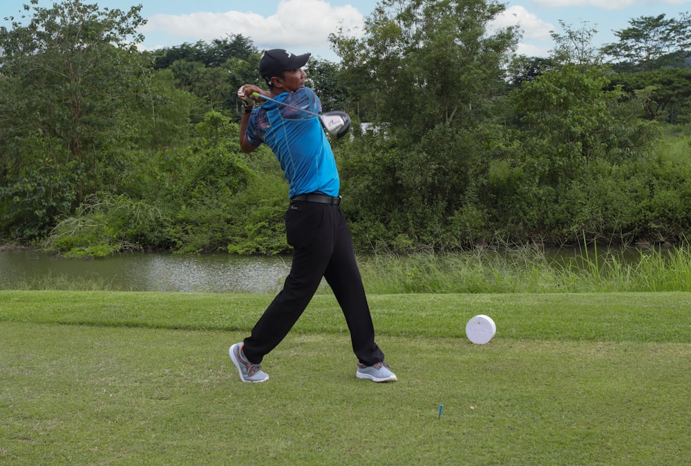 a man swinging a golf club at a ball