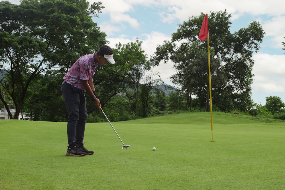 a man putting a golf ball on the green