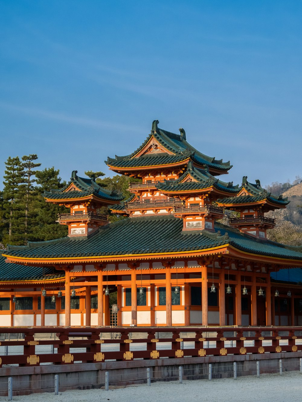 a tall building with a green roof on top of a hill