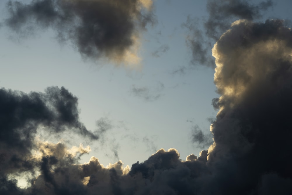 a plane flying through a cloudy blue sky