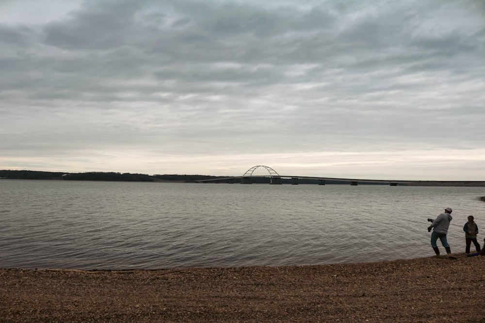 a group of people standing next to a body of water