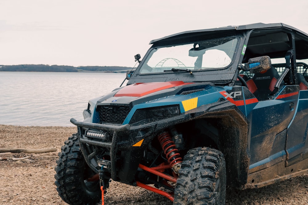 a large blue and red vehicle parked on a beach