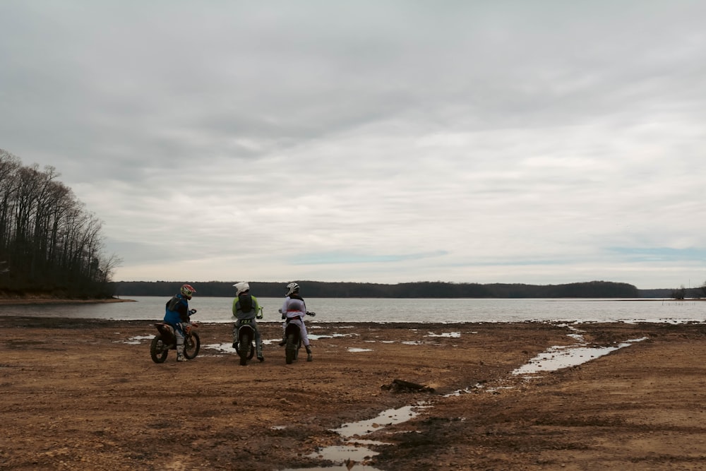 a couple of people on dirt bikes near a body of water