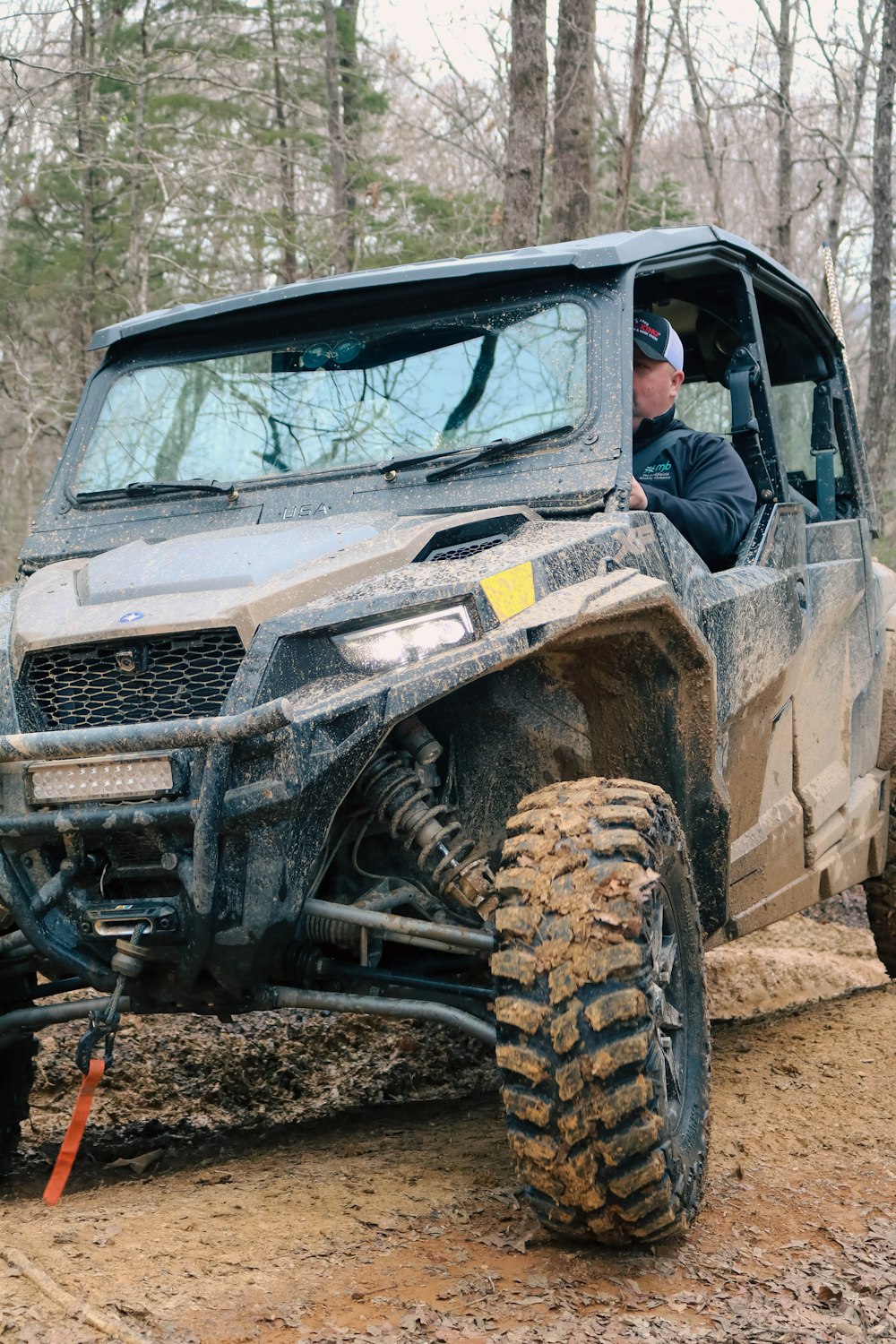 a man driving a vehicle on a muddy trail