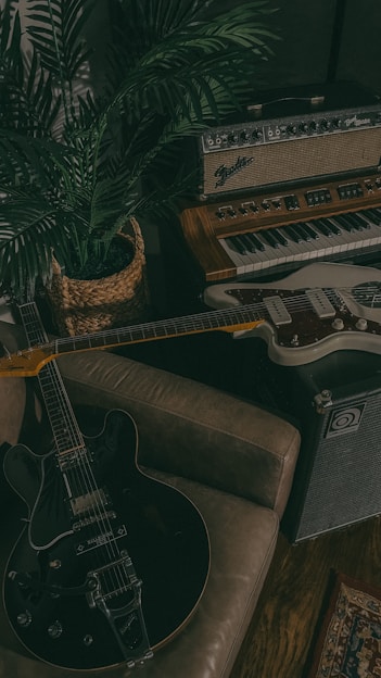 A cozy studio corner filled with colorful sketches, puppets, and a guitar resting nearby.