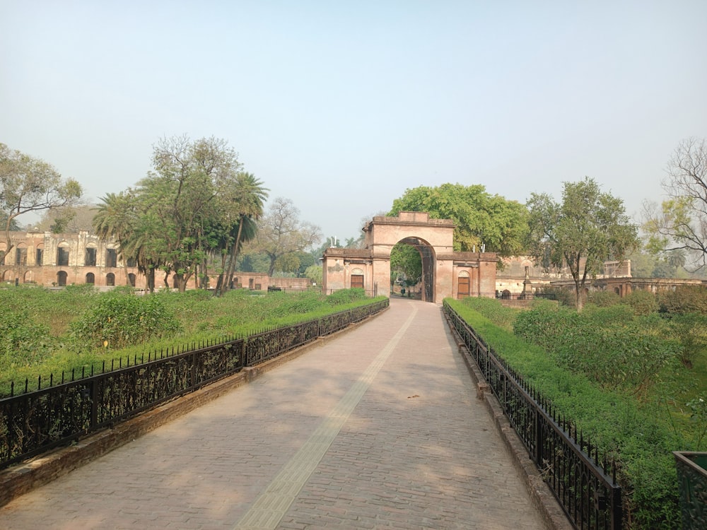 a gated walkway leading to a building in a park