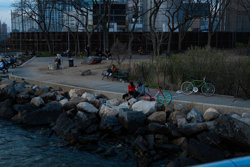 a group of people sitting next to a body of water